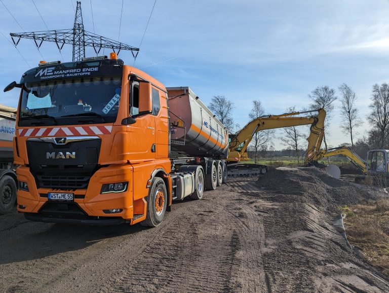 Lkw und Bagger der Manfred Ende GmbH beim Wegebau und Materialeinbau in Westerstede.